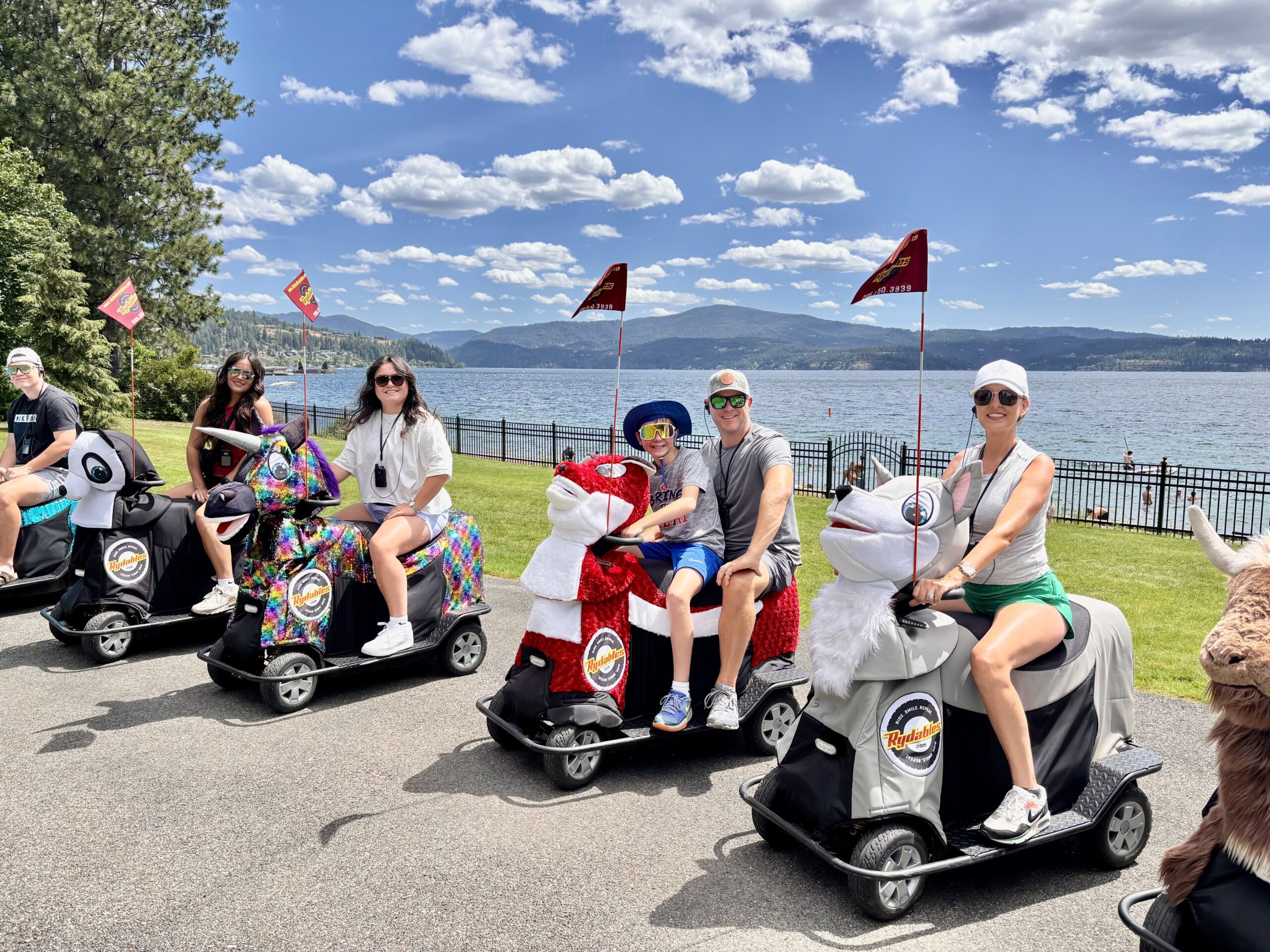 Rydables Discover Coeur d' Alene Tour — group on animal electric scooters with Lake Coeur d' Alene in the background on a sunny day